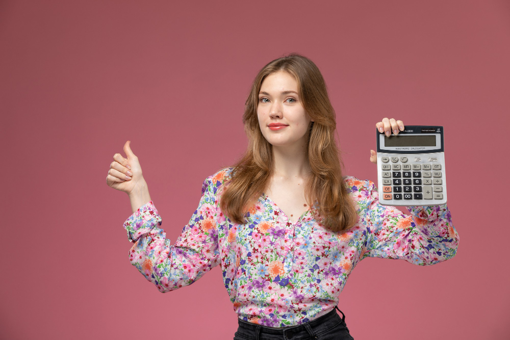 Mujer feliz con calculadora en mano durante la cuesta de enero